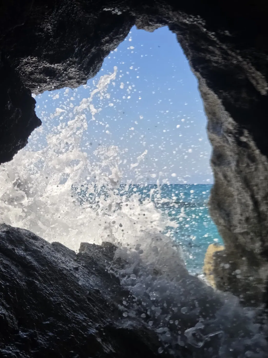 Onde che si infrangono contro una grotta rocciosa sulla costa calabrese